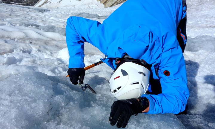 <strong>Bergsteiger dreht eine Eisschraube in das Gletschereis und baut einen Sicherungspunkt (Abalakov-Eissanduhr) zum Abseilen oder Sichern im Eis</strong> <span class=>© Christoph Puggl</span>