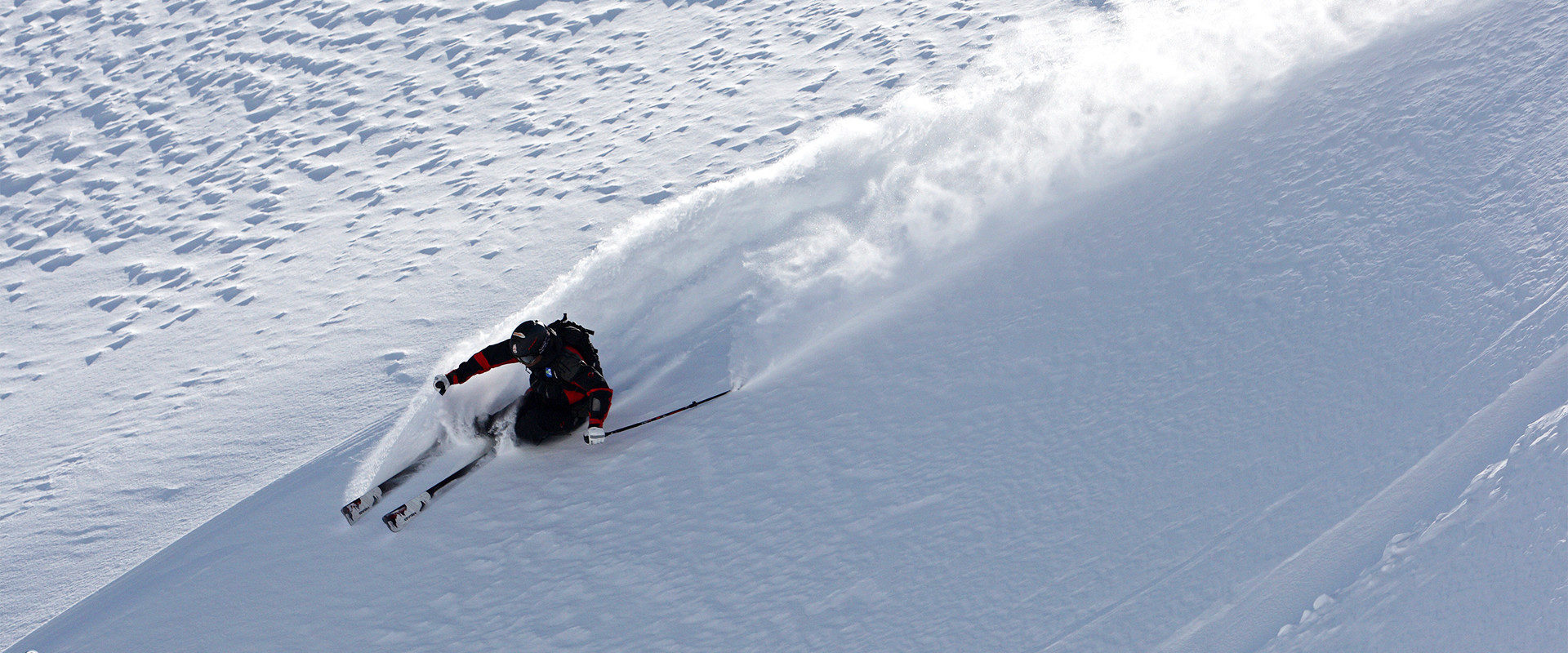 Hannes Rottensteiner beim Freeriden im freien Skigelände mit staubender Schneefahne