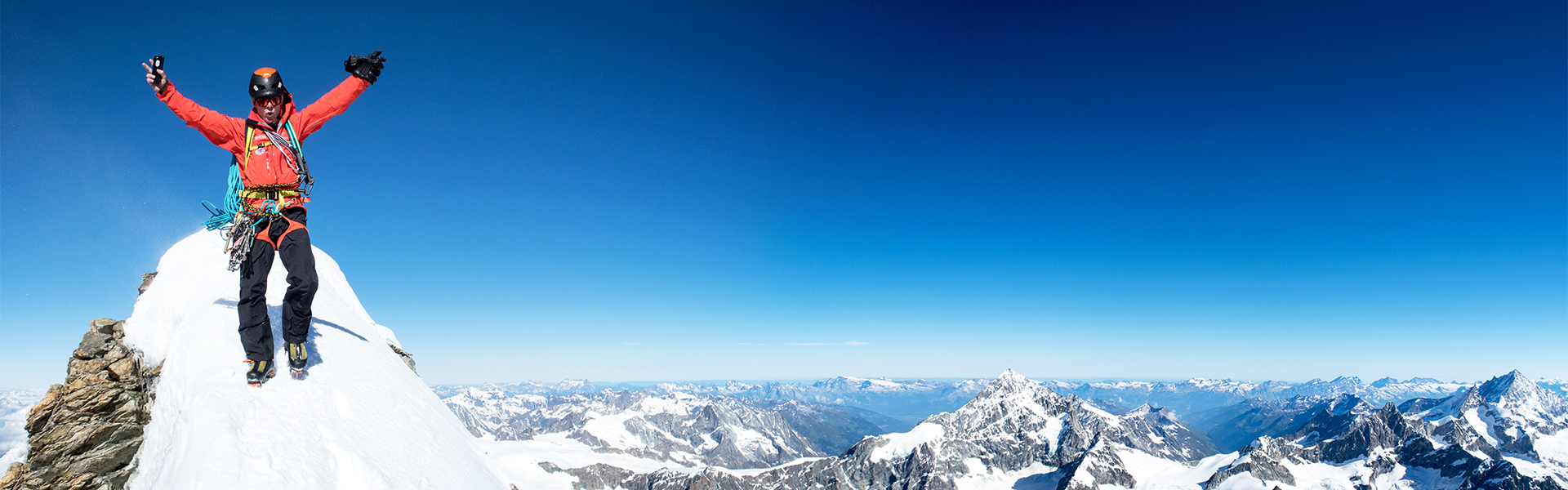 Bernhard Egger am Gipfel vom Matterhorn mit erhobenen Armen in Gipfelpose und Bergpanorama in Zermatt - Walliser Alpen.