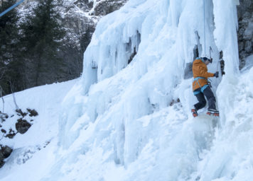 Thumbnail http://Eiskletterin%20steigt%20an%20gefrorenem%20Wasser%20mit%20Eisgeräte%20empor.