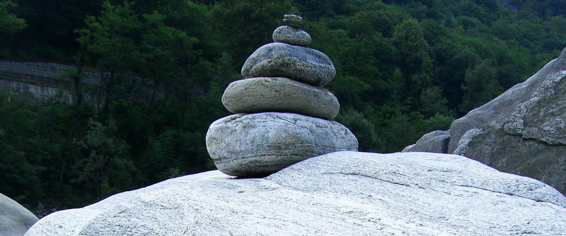 Ein Steinmandl oder Steinmann im Tessin - Landart mit natürlichen Materialien oder ein Wegweiser / Markierung im alpinen Gelände.