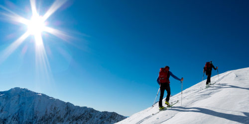 Zwei Skitourengeher im Aufstieg in verschneiter Winterlandschaft