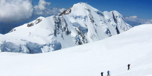 Drei Bergsteiger im Schnee auf dem Weg zum Gipfel