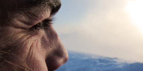 Mann schaut zu Sonnenaufgang mit Augenbraun und Hautfalten