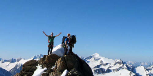 Drei Bergsteiger auf Gipfel