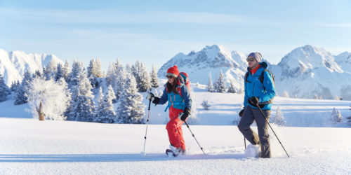 Schneeschuhgeher im Pulverschnee stapfen im Abendlicht