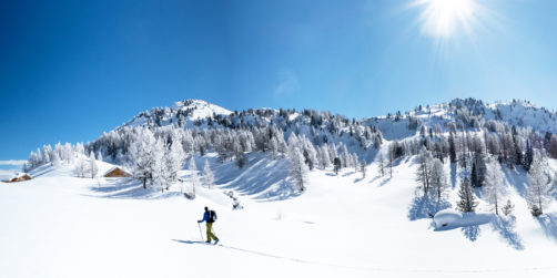 Skitourengeher mit traumhaften Panorama und weite Winterlandschaft bei Sonnenschein